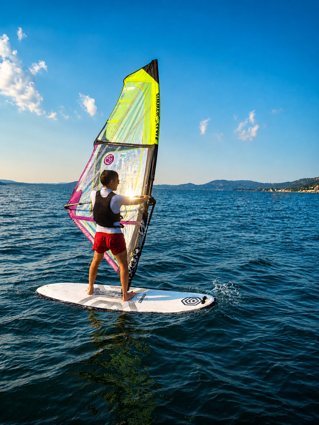 Windsurfista al tramonto sul lago